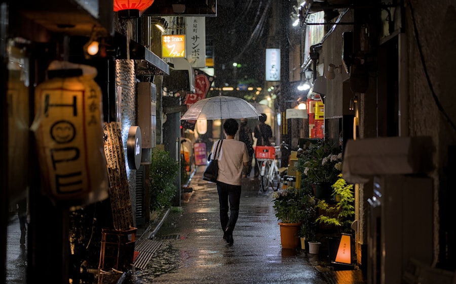 A person walks in a rainy, dimly lit alley.