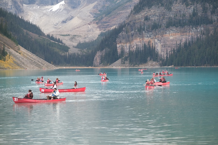 Canoes float on a turquoise lake with mountains.