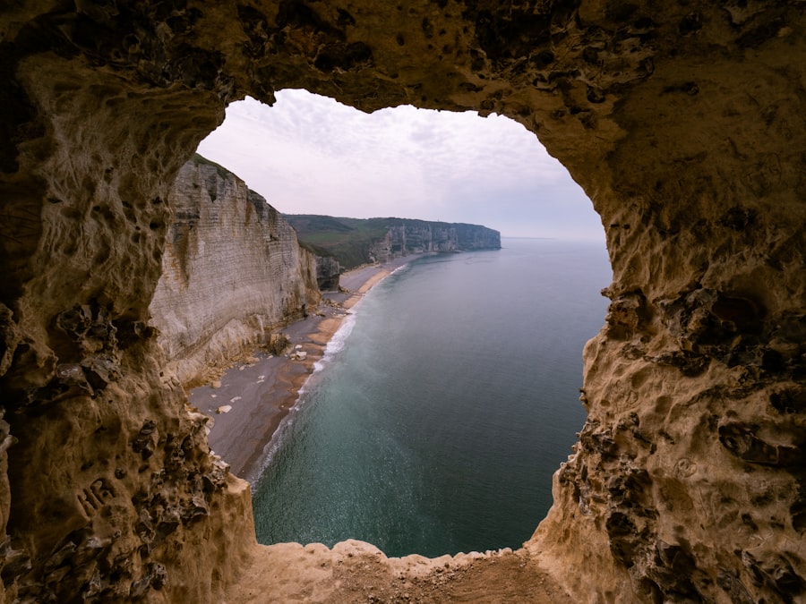 Coastal cliffs and beach viewed through a natural cave opening.