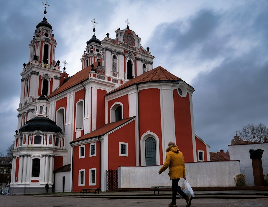 A person walks past a red and white church.