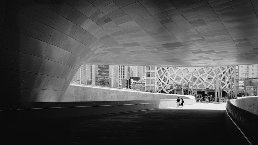 Curved concrete structures frame a distant modern city scene