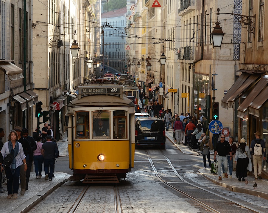 A yellow tram rides down a street in lisbon