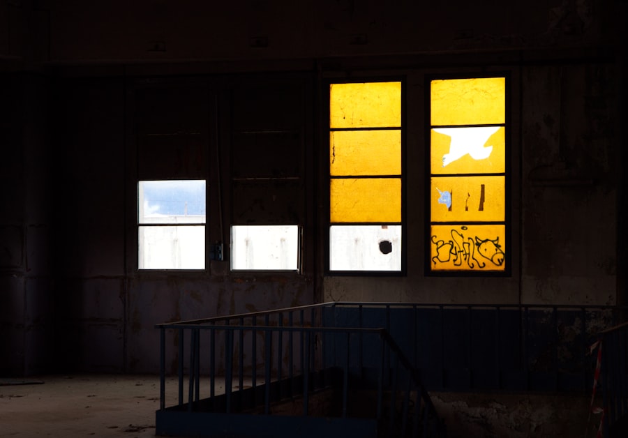 Broken yellow windows in a dark, abandoned building.
