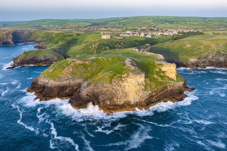 Waves crash around a rocky island near a coastal town.