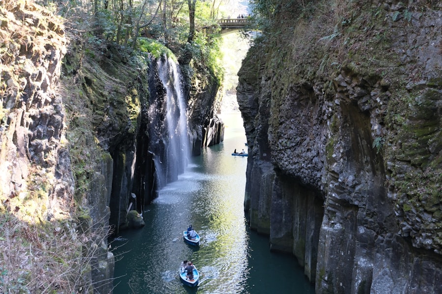 Boats navigate a narrow gorge with a waterfall.
