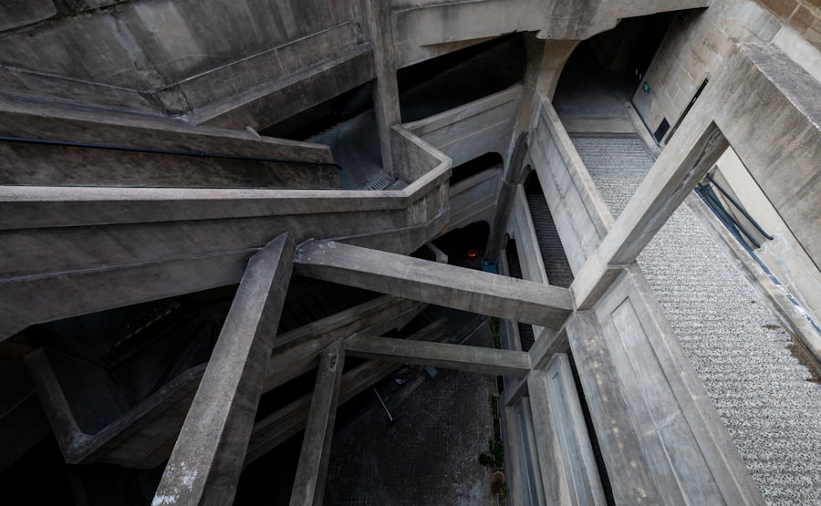 Concrete stairs spiral down inside a structure.