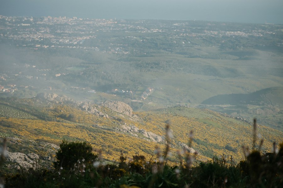 Hazy landscape with rolling hills and distant city
