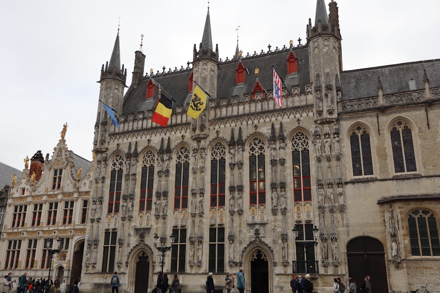 Elaborate historic building with flags under cloudy sky.