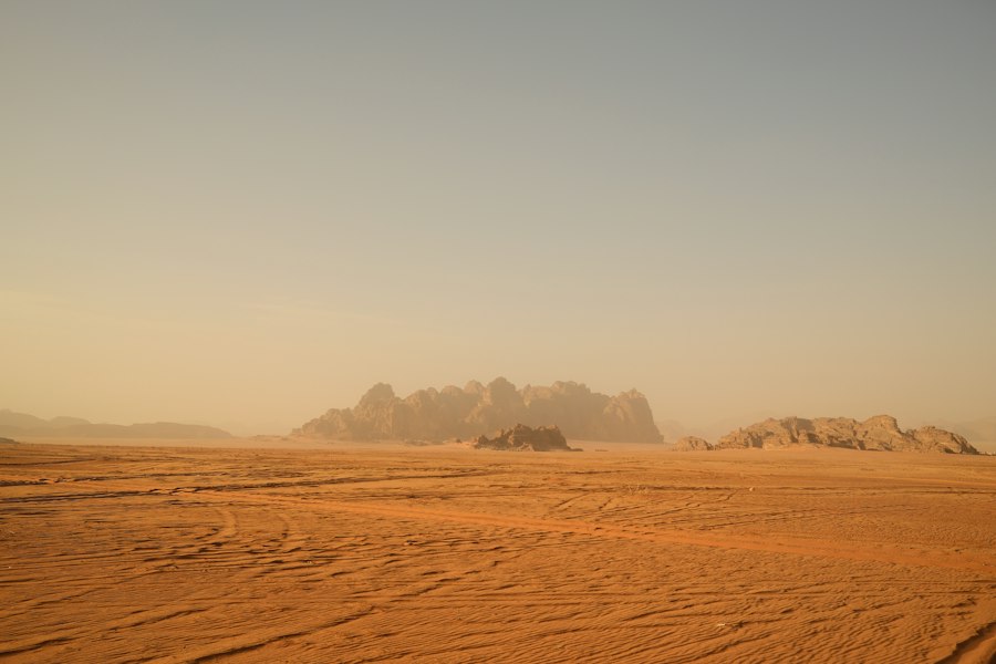 Vast desert landscape with rocky formations under a clear sky