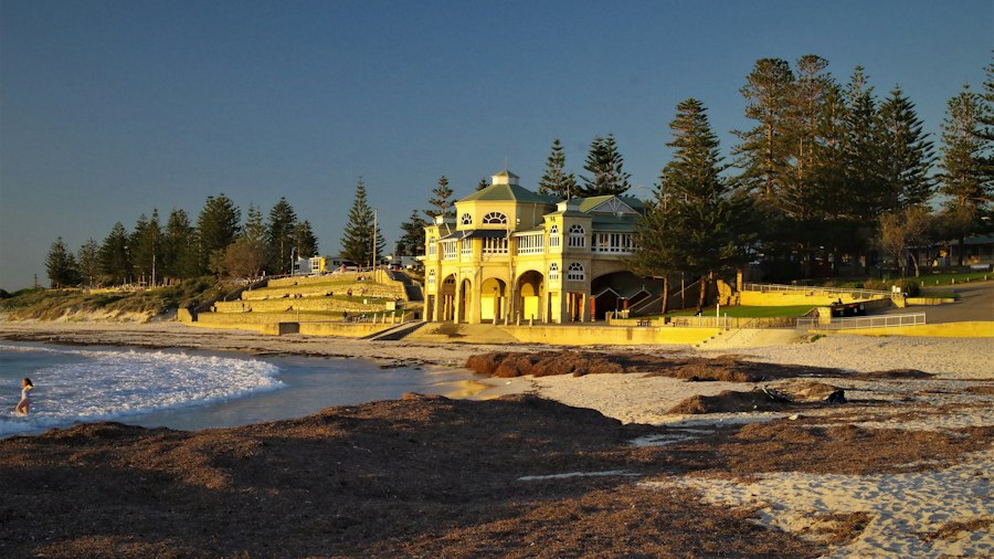 a yellow building sitting on top of a sandy beach