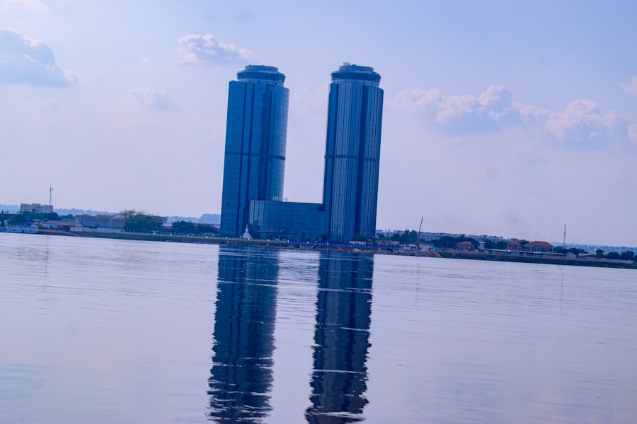 Two modern blue skyscrapers reflected in water