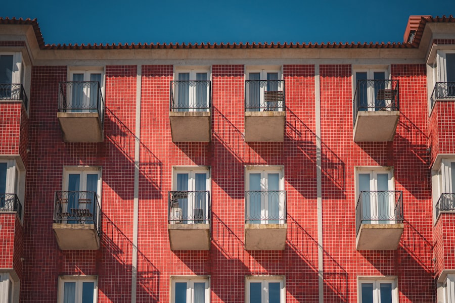 Red brick building facade with many windows and balconies.