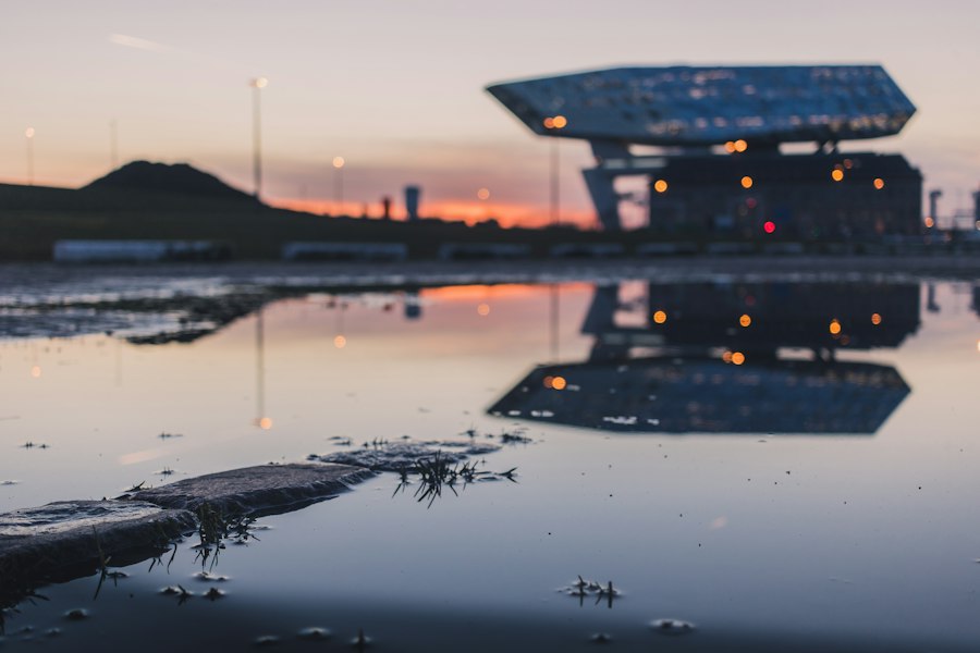 selective focus photo of calm water near building at golden hour