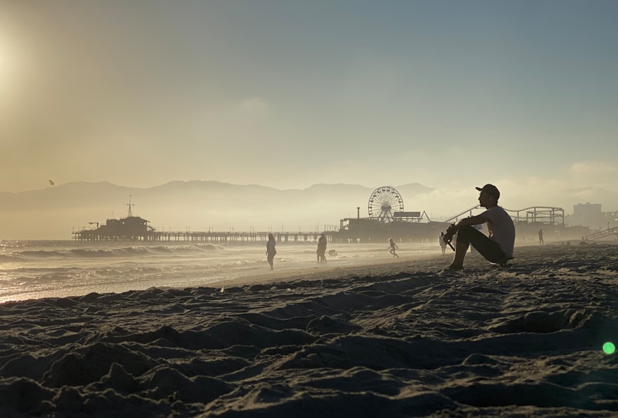a man sitting on a beach next to the ocean
