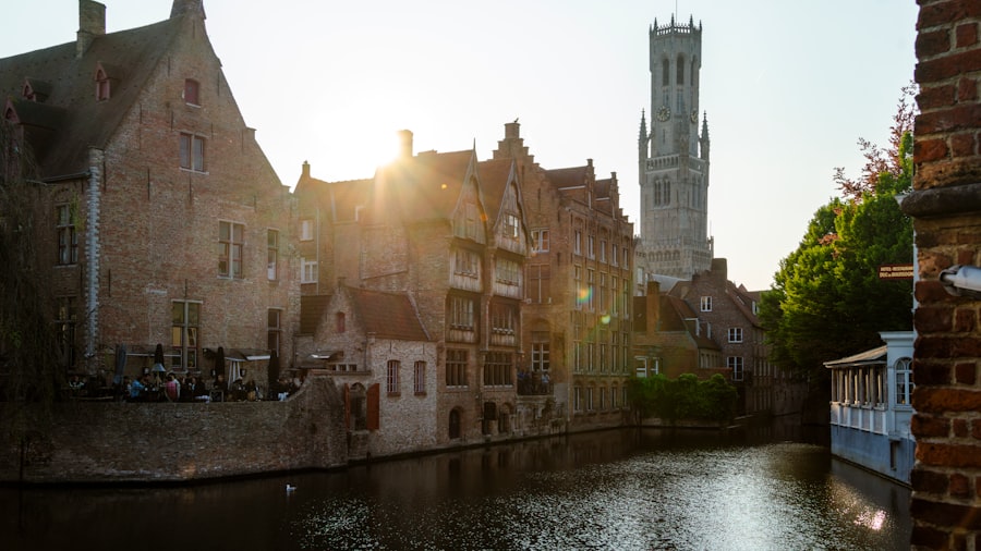 Buildings line a canal, with a tower in the distance.