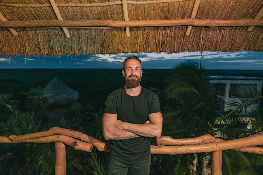 a man standing in front of a bamboo roof