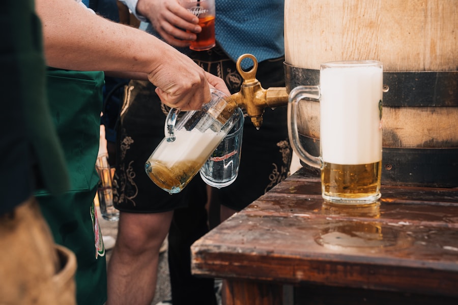Pouring beer from a wooden barrel into a glass mug.