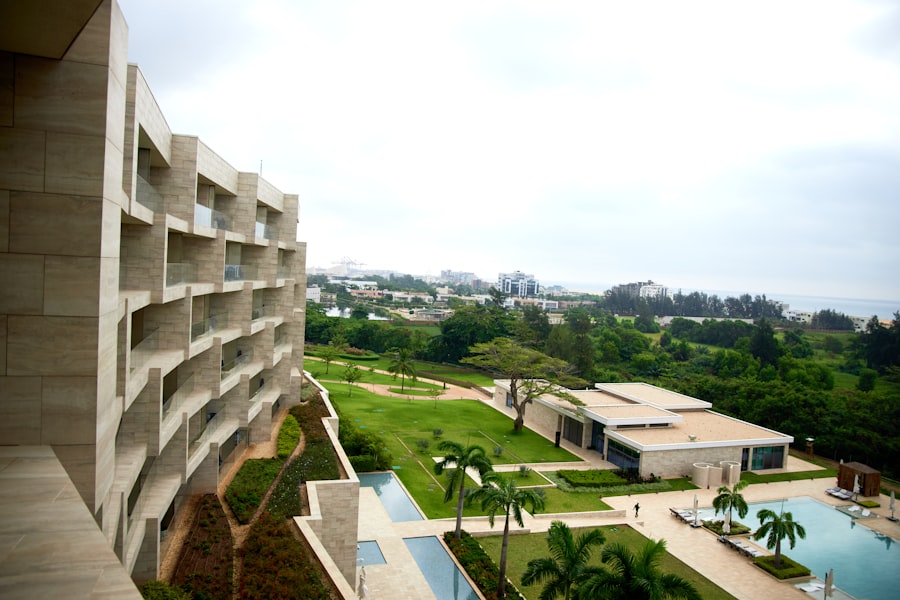 Modern resort building overlooking a lush garden, pool, and ocean