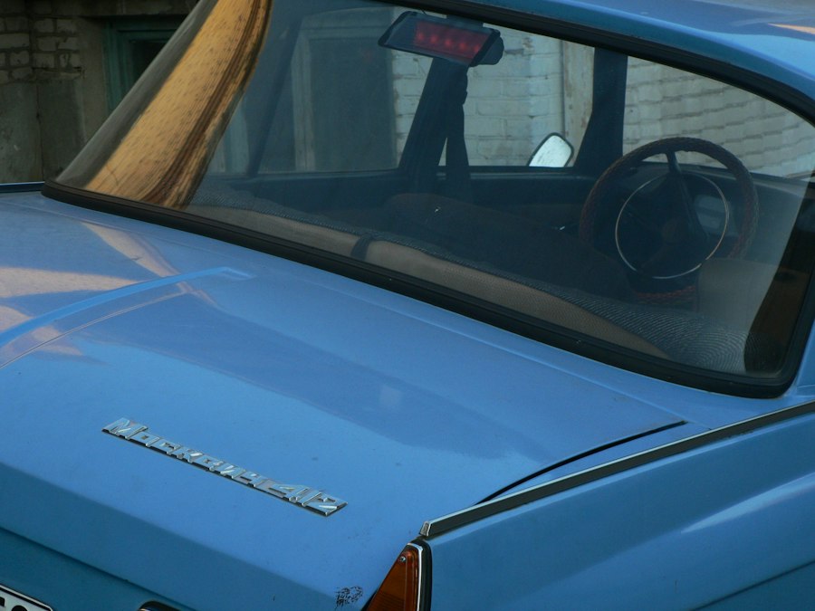 The rear of a light blue Moskvitch 412 car with a visible steering wheel