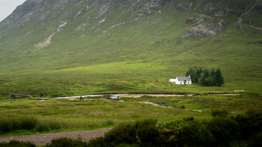 Remote white house in a vast green mountain valley