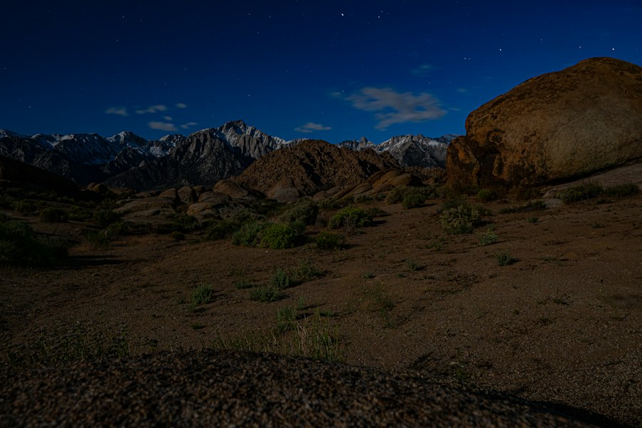 a large rock sitting in the middle of a desert