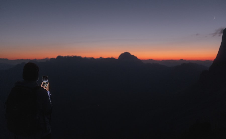 a person taking a picture of a sunset
