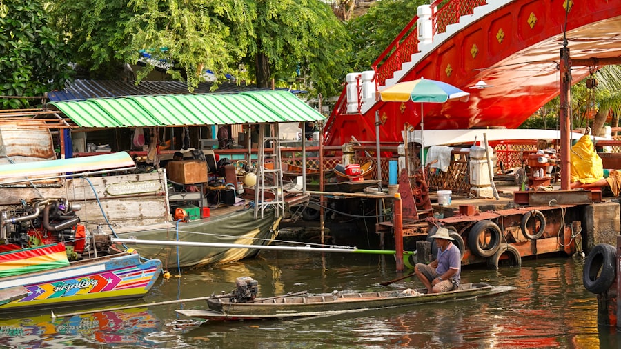 A man rows a boat in a bustling floating market.