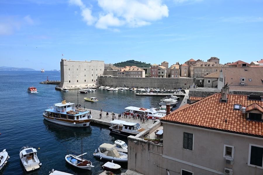 Historic harbor with boats and ancient city walls.
