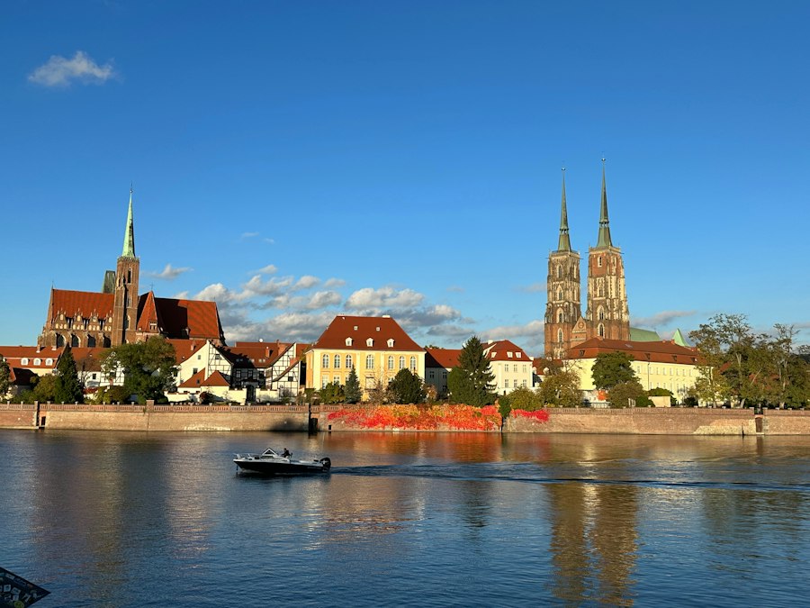 A boat traveling down a river next to a city