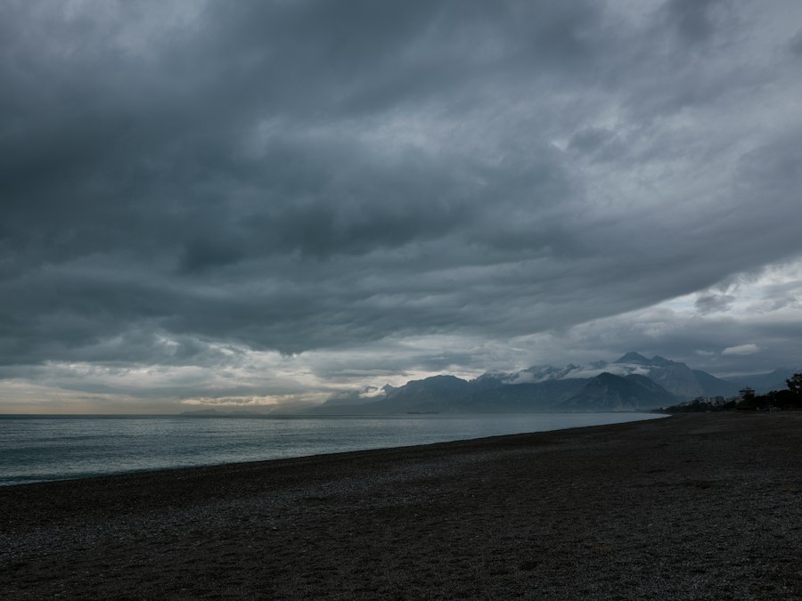 Dark clouds over a beach and distant mountains