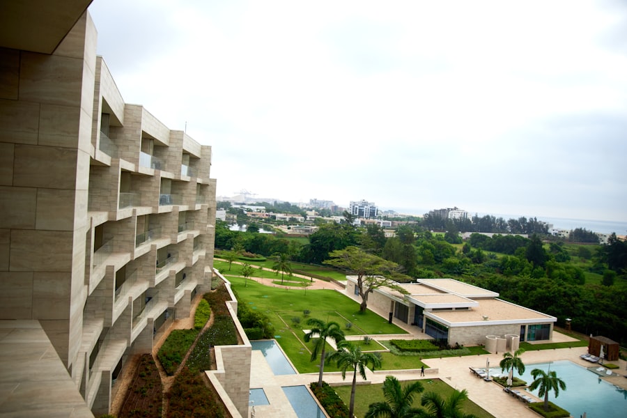 Modern resort building overlooking a lush landscape and swimming pool.