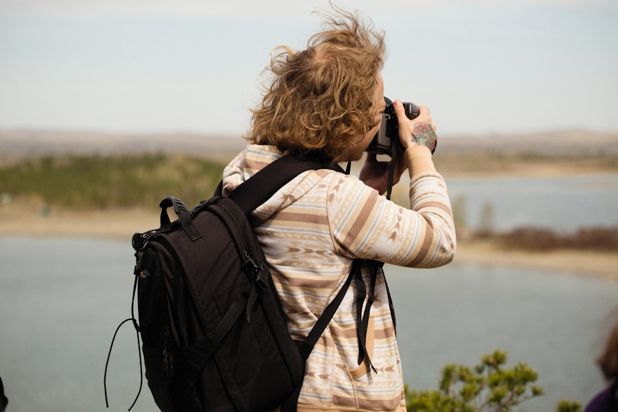 a woman taking a picture of a lake with a camera