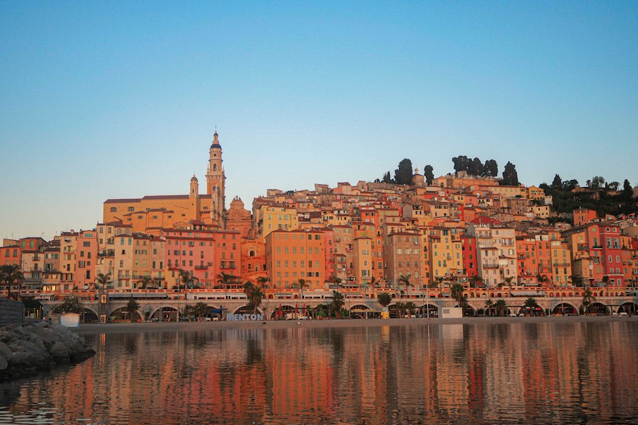 Colorful buildings line the coast with a clear blue sky
