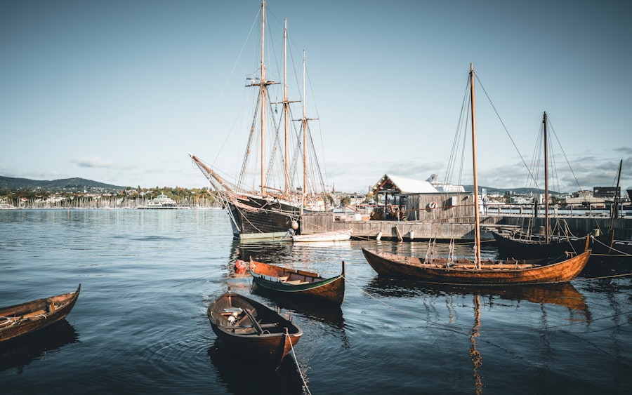 Boats and a tall ship float in tranquil waters.