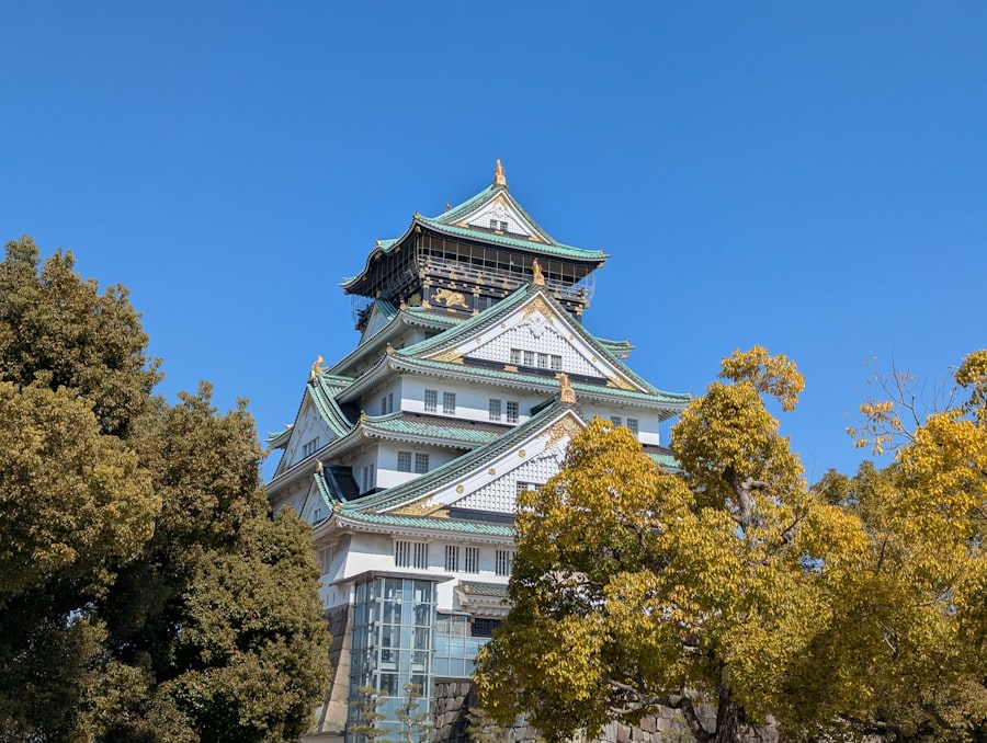 Osaka castle stands tall against a blue sky.
