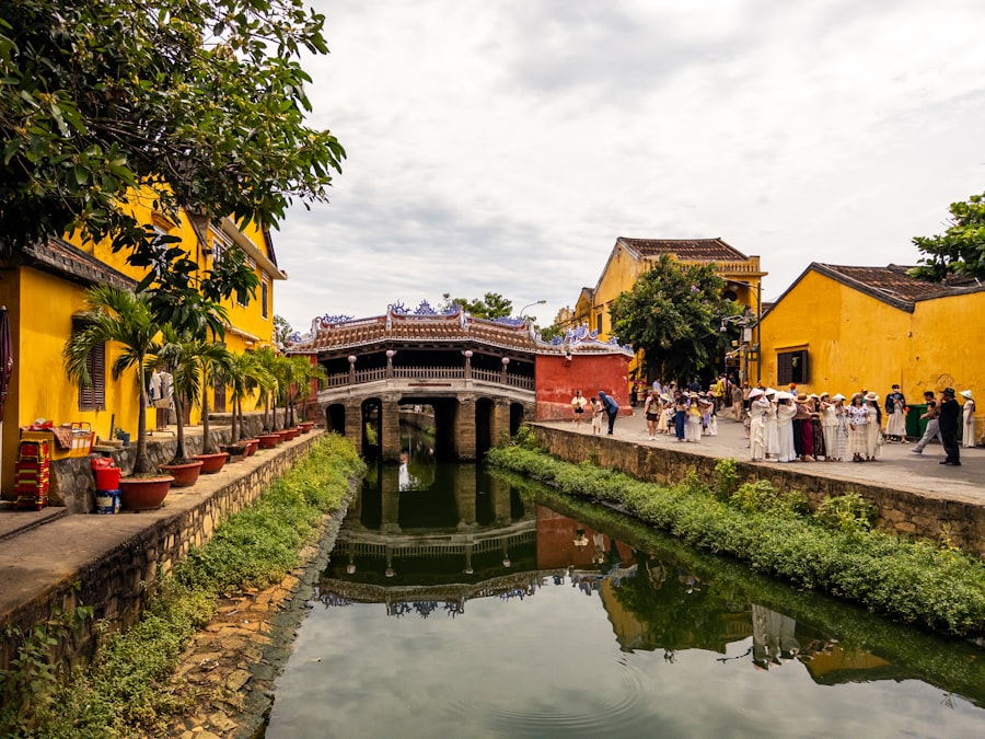 A canal flows between yellow buildings with a historic bridge.