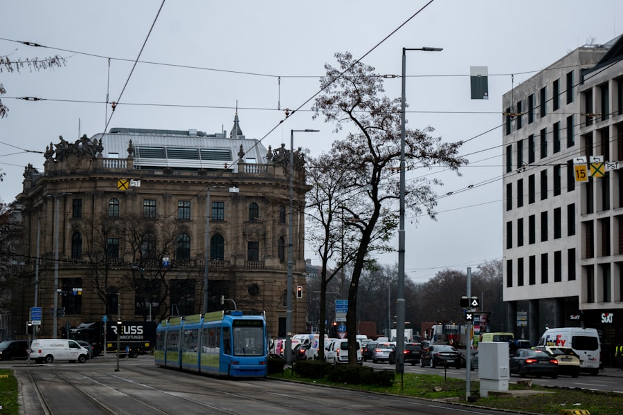 Blue tram on city street with buildings and cars