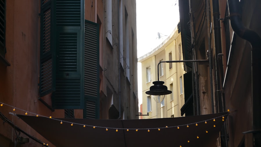 A narrow street leads to a bright open area.