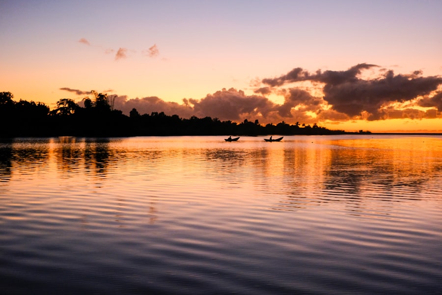 Sunset illuminates calm water and silhouettes.